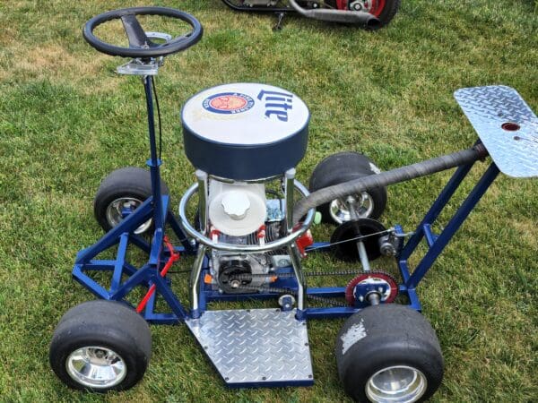 A blue and white lawn mower with a large wheel.