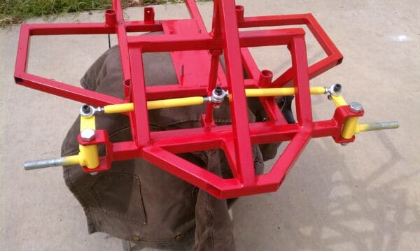 A red cart with yellow pipes on the back.