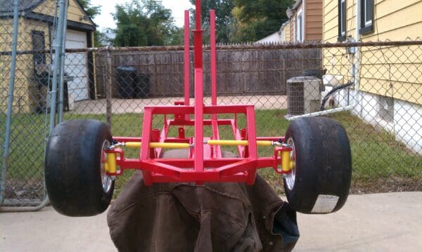 A red cart with two tires on the back.