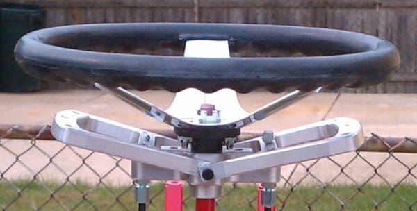 A close up of the steering wheel on a red and silver stand