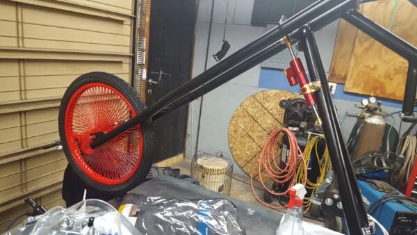 A large red wheel sitting on top of a metal pole.