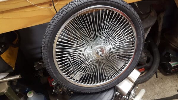 A tire with a wheel on it sitting in the middle of a garage.