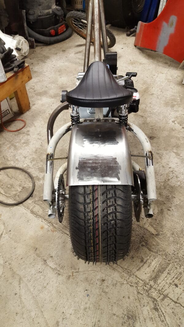 A motorcycle is parked on the ground in a garage.