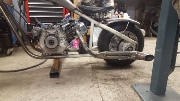 A motorcycle is being worked on in the garage.