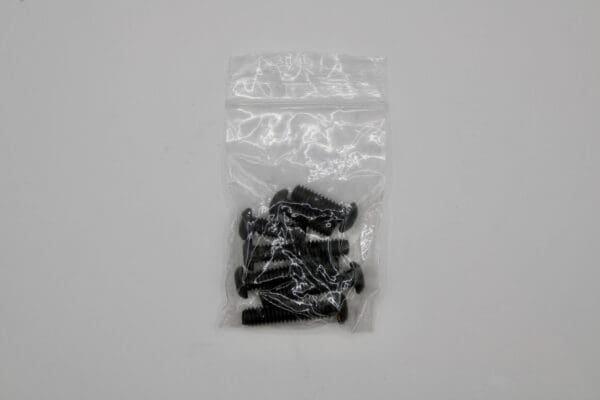 A bag of black screws sitting on top of a table.